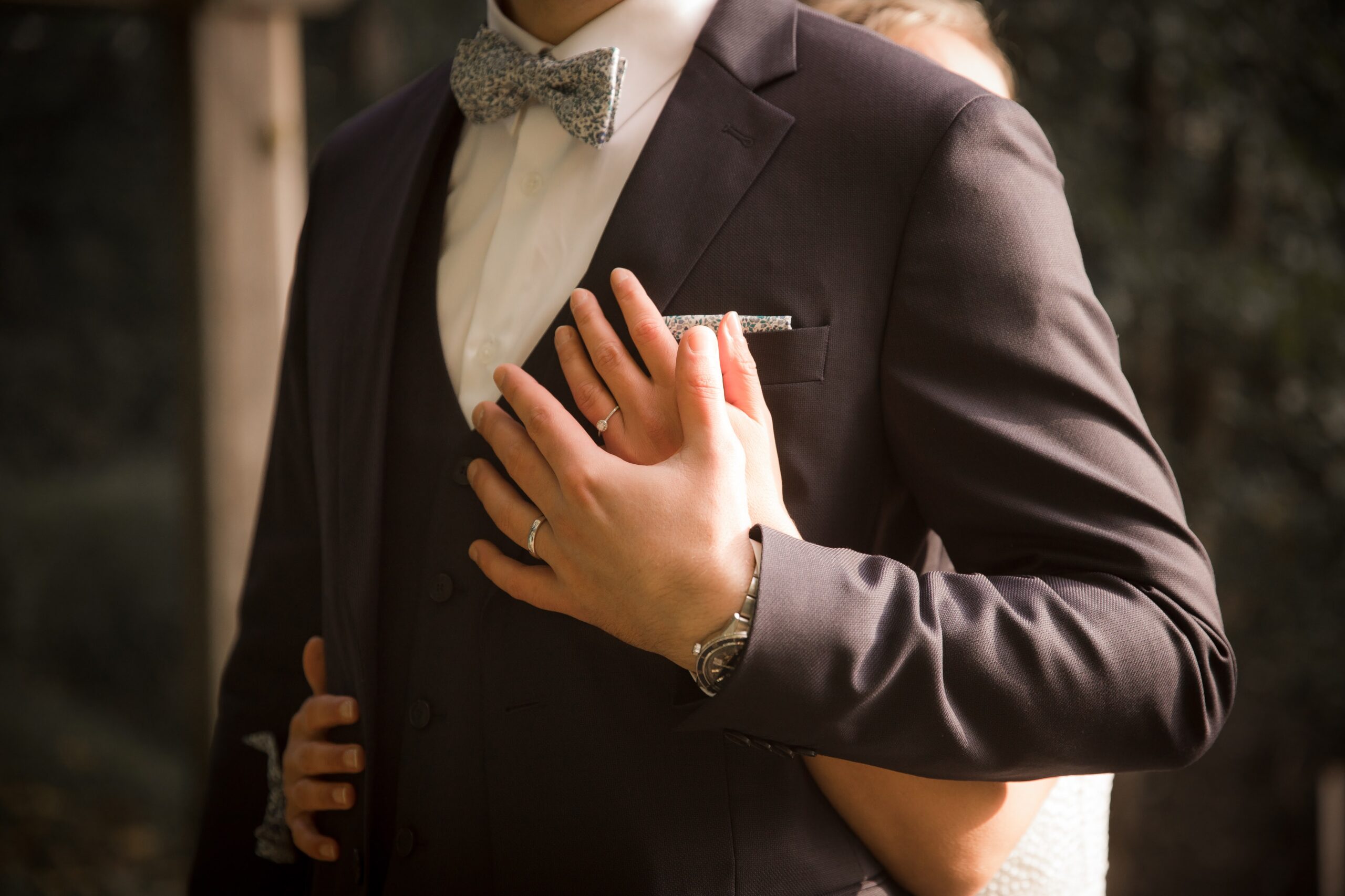 Image de deux mariées se tenant la main à leur mariage.